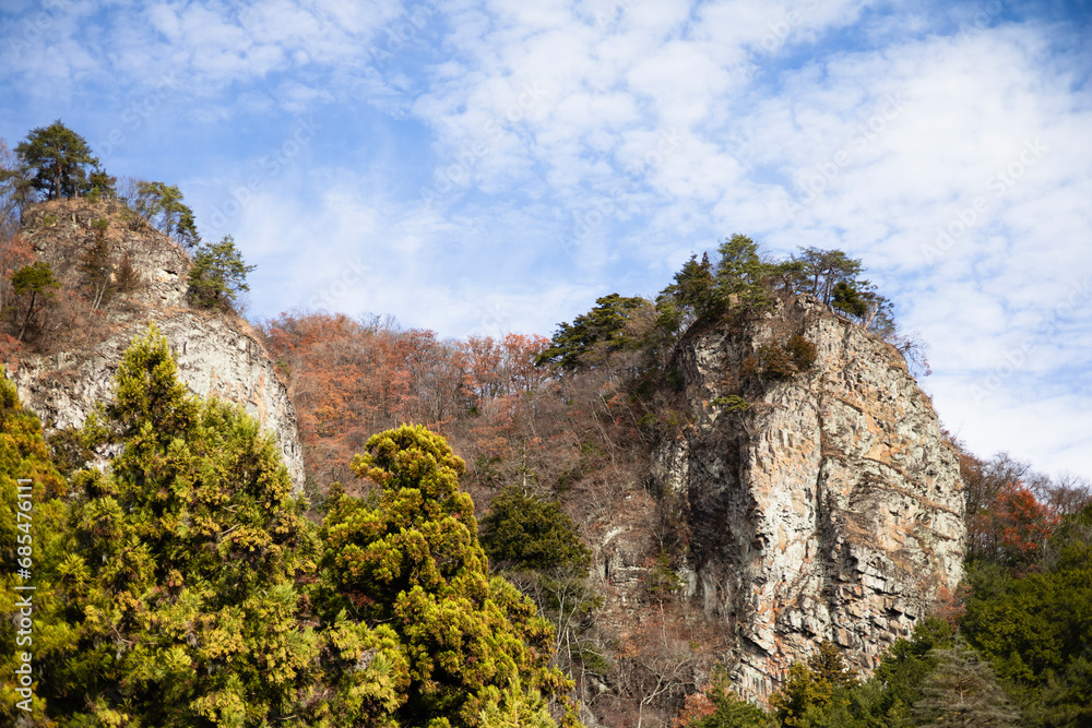 秋の青空と紅葉の岩山の風景
