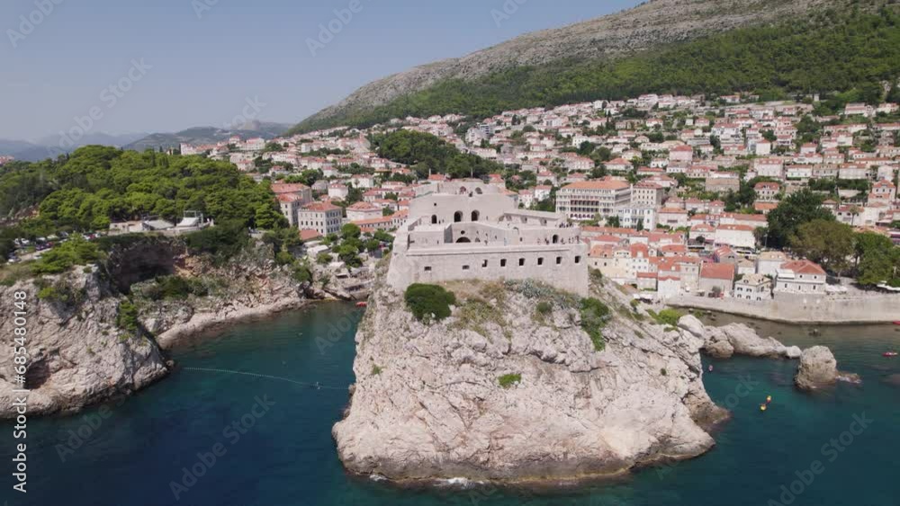 Rugged cliffs hold up Fort Lovrijenac in Dubrovnik Croatia, aerial pullback Rugged cliffs hold up Fort Lovrijenac in Dubrovnik Croatia, aerial pullback