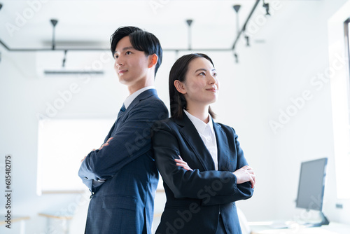 オフィスで腕組をする若手のビジネスマン