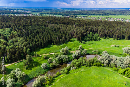 Scenic drone view of a coniferous forest on a hilly area near a river