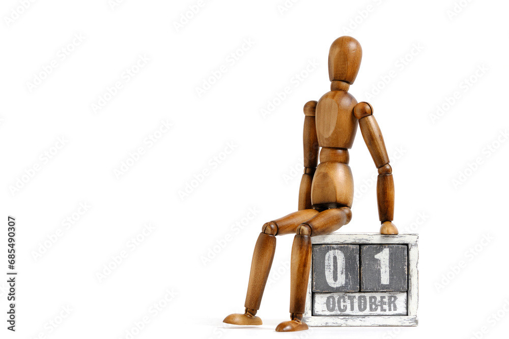 October 01, wooden calendar with mannequin sitting on it on white background. Calendar date. October 01, wooden calendar with mannequin sitting on it on white background. Calendar date.
