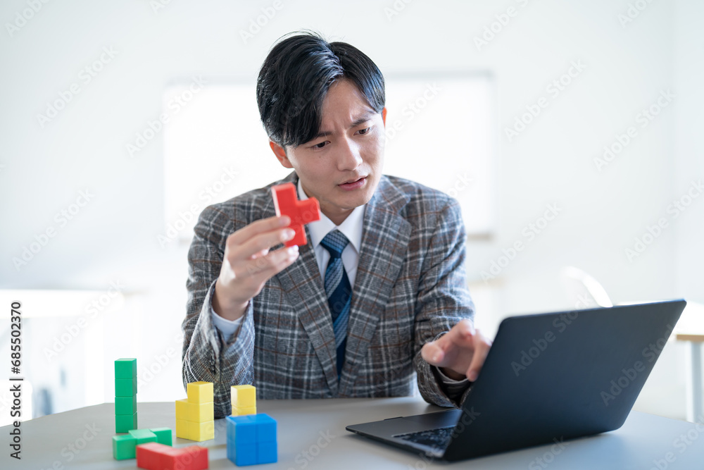 ブロックを持ち考える若いジャケットを着た男性 ブロックを持ち考える若いジャケットを着た男性