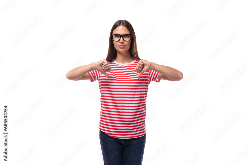 beautiful young caucasian woman with straight hair with glasses and in a striped t-shirt shows a dislike with her hands beautiful young caucasian woman with straight hair with glasses and in a striped t-shirt shows a dislike with her hands