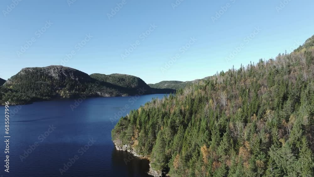 Hildremsvatnet, Trondelag County, Norway - Calm Blue Waters Enveloped by Lush Greenery, With a Distant Mountain Range Completing the Tranquil Panorama - Aerial Drone Shot
