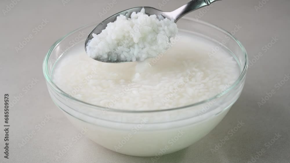 Serving rice water in a bowl. Cooked soaked rice water in a bowl.