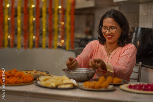 Senior woman making laddoo on the occasion of Diwali photo