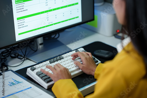 Fotografie Successful Asian businesswoman sitting at desk typing numeric data on PC keyboard in modern office Business technology career concept