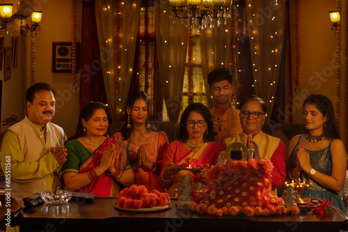 Indian family worshipping God at home on the occasion of Diwali photo