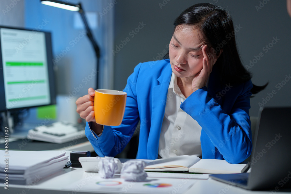 Asian businesswoman or female office worker holding a coffee cup is stressed and tired with failed work documents. unsuccessful Depression overworked Office Syndrome.