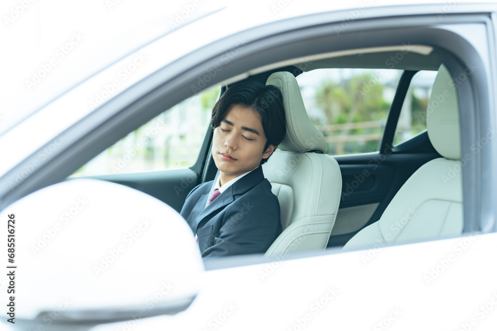 自動車の車内で眠るドライバー　自動運転　休憩　車中泊