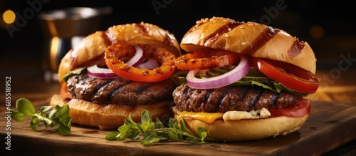 Two handcrafted burgers with roasted sausage, onion rings, and tomato-onion salad, dressed with vinaigrette.