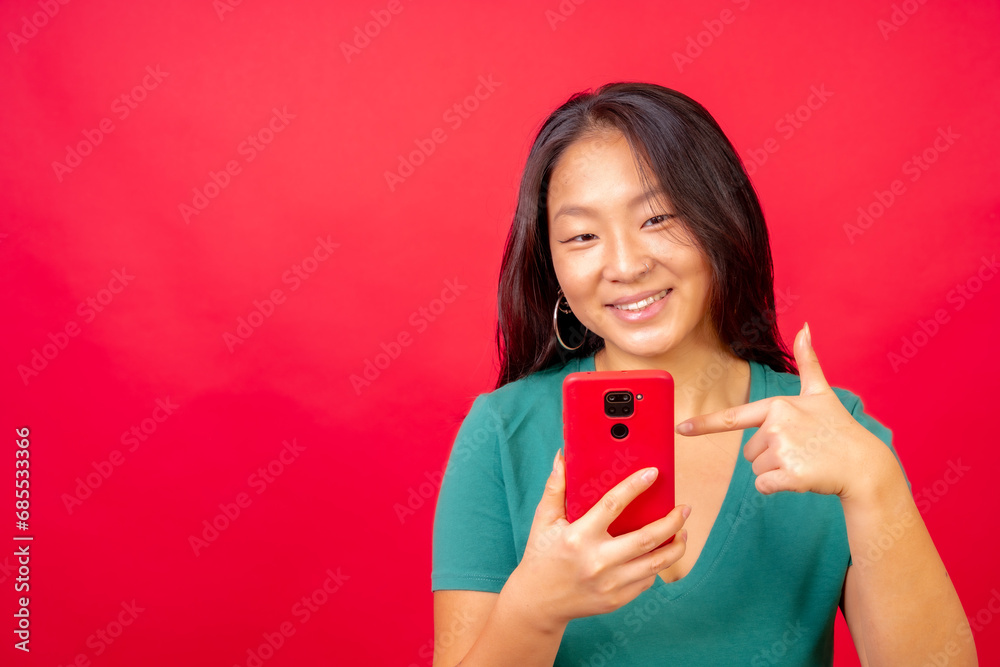 Chinese woman pointing to a mobile phone Chinese woman pointing to a mobile phone