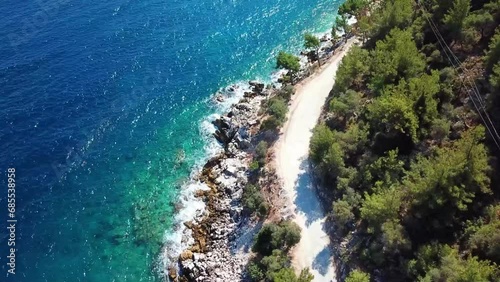 Unpaved road near the sea shore near Marble Beach or Saliara Beach in Thassos Island , Greece , well known tourist attraction at Aegean Sea , famous for it's pure white marble sand , aerial view