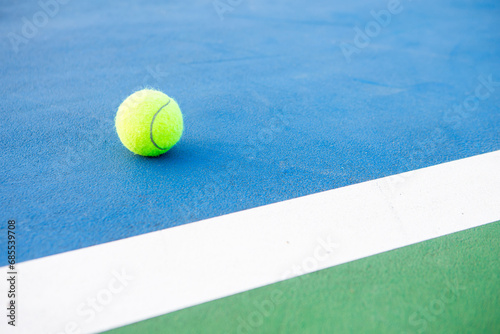 Tennis ball on a blue paddle tennis court. © Nitiphol