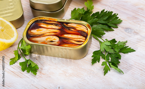 Marinated in oil mussels served in tin with lemon and parsley photo