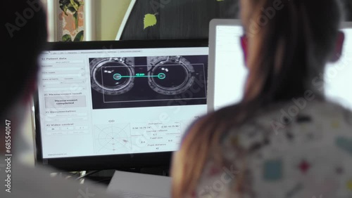 Ophthalmologists look at recorded pupil measurements of eyesight with strabismus. Optometrist works in specialized software program. Eye health monitoring. Test results on computer monitor photo