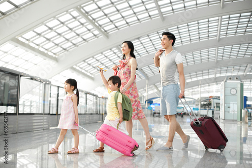 Happy young family leaving with luggage
