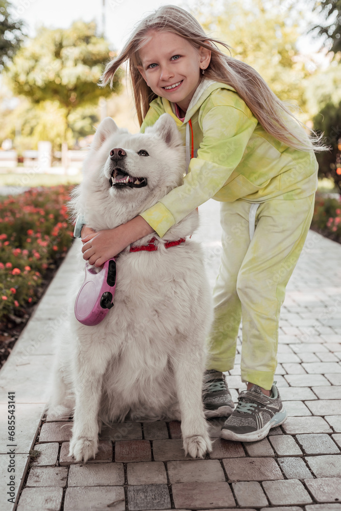 A girl walking with a dog in the park. A child hugs a dog. A girl walking with a dog in the park. A child hugs a dog.