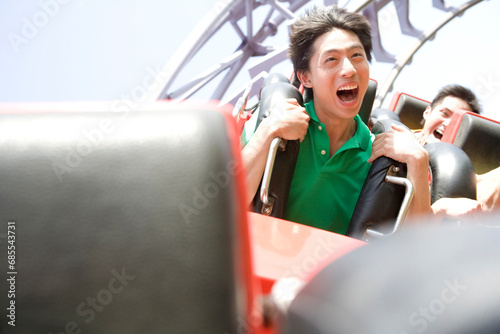 Young people riding a rollercoaster photo
