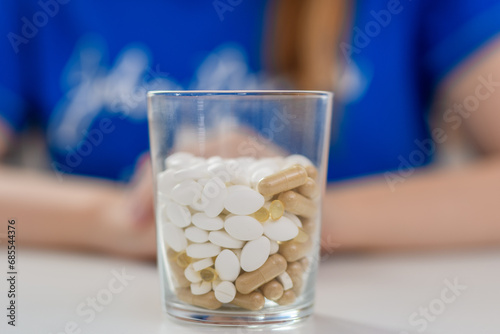 Szklanka tabletek nasennych na rozmytym tle 