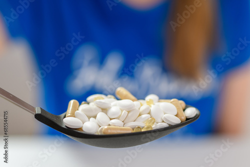 Łyżka kuchenna wypełniona lekami - tabletkami i kapsułkami 