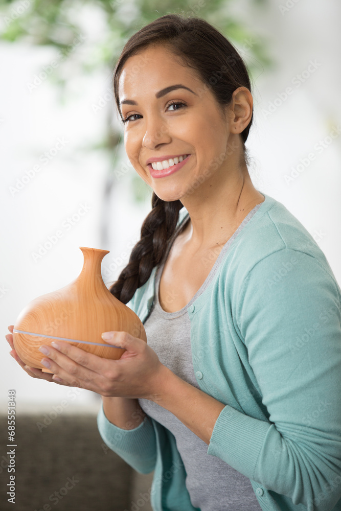 beautiful woman holding an essential oil diffuser beautiful woman holding an essential oil diffuser