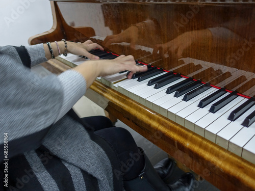 Pianist playing piano, classical music - reflection of hands and keyboard photo