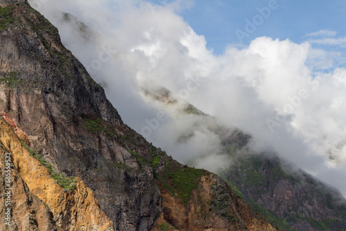 Spectacular and amazing beautiful panorama of the Andes Mountains in the Colca Canyon, Peru. White clouds, blue sky. Wonderful colorful cloudscape.