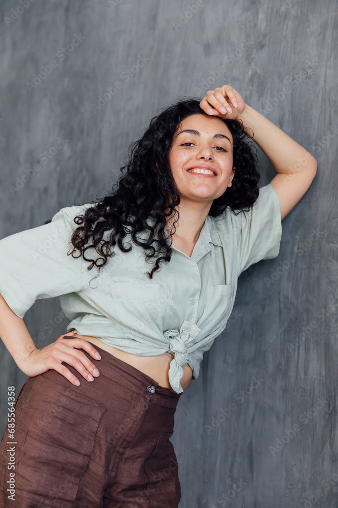Fototapeta premium Portrait of a beautiful fashionable woman with black curly hair