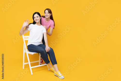 Two young girls on a yellow background