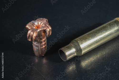 Expansive crumpled 308 caliber bullet and spent cartridge case, close up. photo