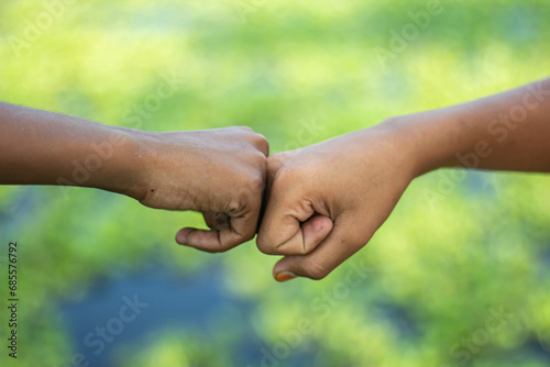 Two human hands are joined together fists and blurred background © Rokonuzzamnan