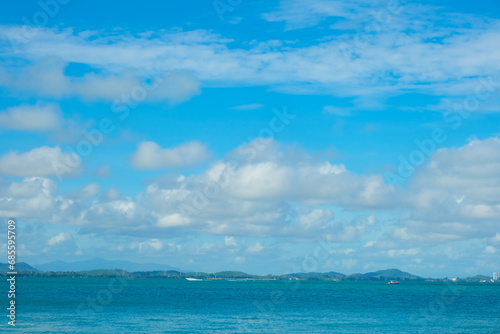 Tropical sea beach wave against blue sky with fluffy cloud