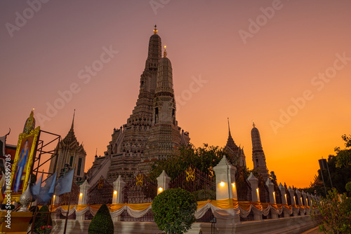 scenery sunset behind the large illuminated temple Wat Arun the biggest and tallest pagoda in the world beside Chaophraya river Bangkok  Thailand..pagoda in golden sunset popular landmark in Bangkok