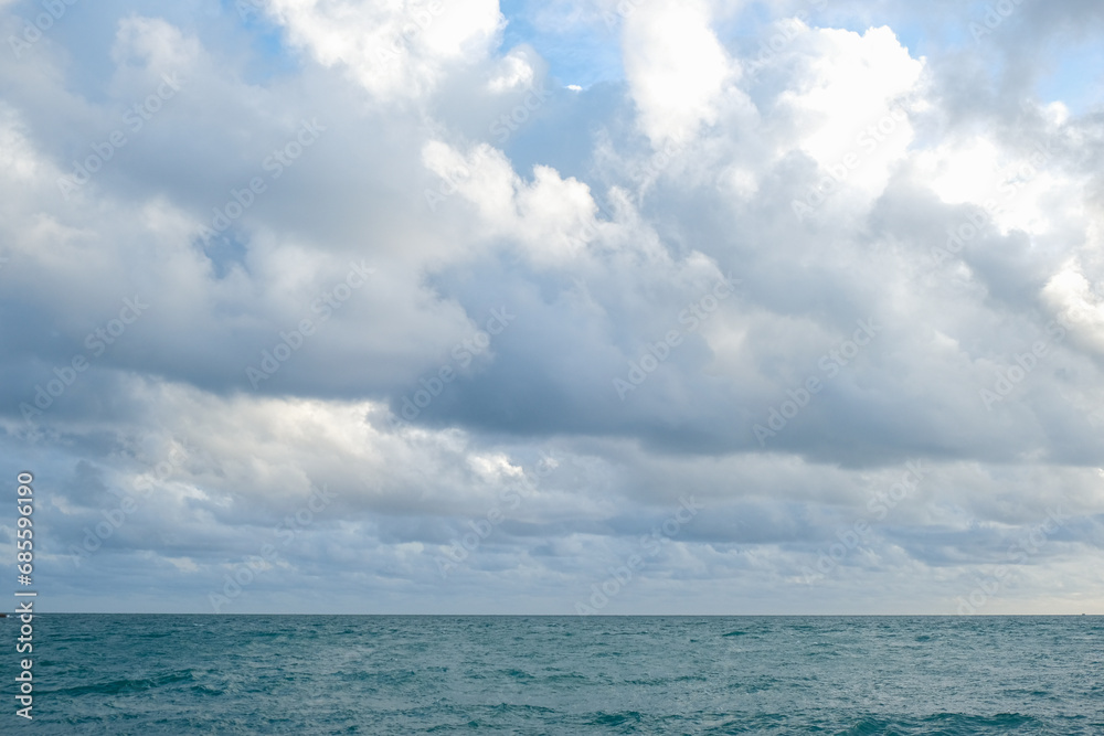 Fototapeta premium Tropical sea beach wave against blue sky with fluffy cloud