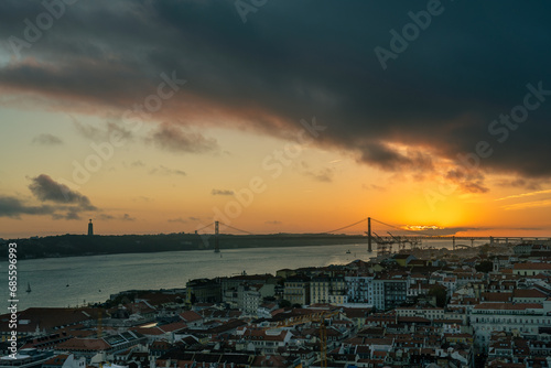 Lisbon at sunset, cityscape with orange sky and dark clouds
