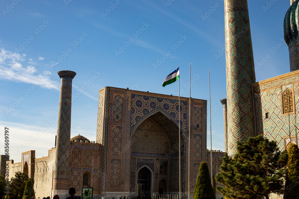 historical building in a central Asia with the Uzbekistan flag, Registan square, Samarkand, madrasah.