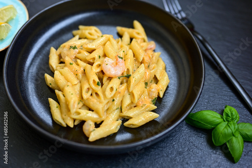  Italian home made pennette pasta with smoked salmon , creamy sauce and fresh dill on wooden background