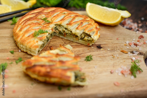 Tasty smokend  salmon  and broccoli pie . Salmon in puff pastry.. Home made healty  quiche ,lemon  and fish on wooden background