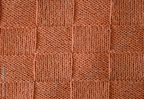 Unusual abstract knitted chess pattern background texture. Top view, close-up. Handmade knitting wool