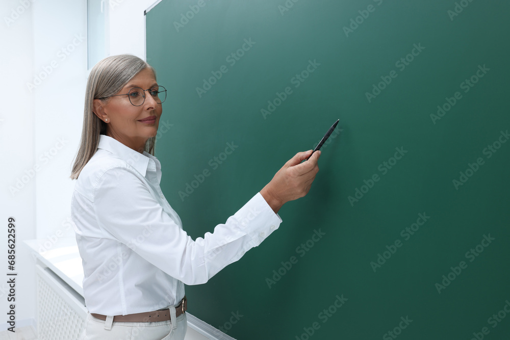 Professor explaining something at blackboard in classroom, space for text Professor explaining something at blackboard in classroom, space for text