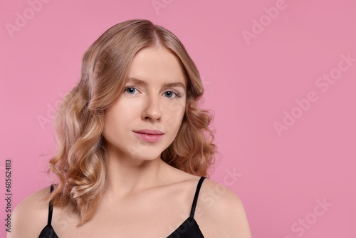 Portrait of beautiful woman with blonde hair on pink background. Space for text