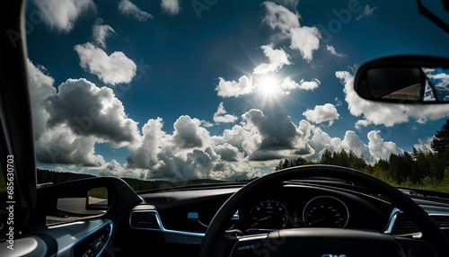 A windshield view from within a clean late-model sedan on a partly cloudy mid-day