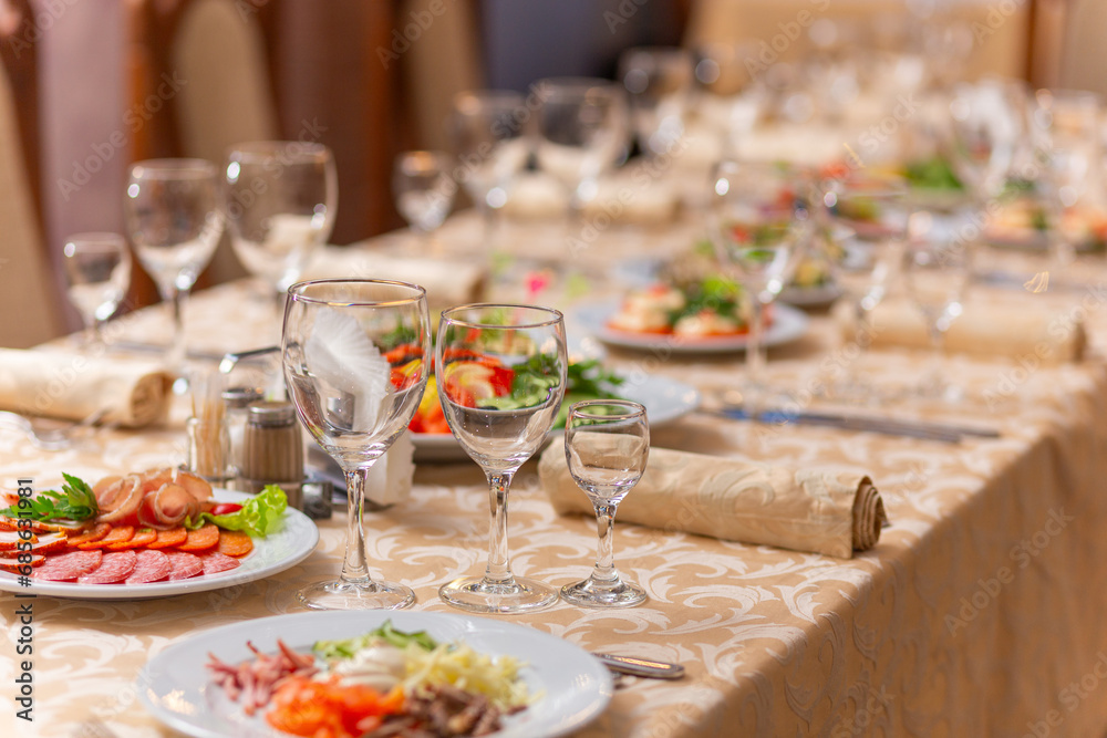 Served festive table with snacks, glasses, glasses, cutlery and napkins for a banquet