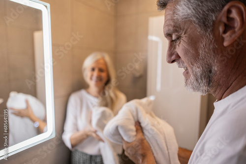 Man holding towel in bathroom at home photo