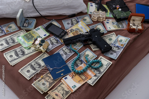 Police handcuffs lies on a set of green monetary denominations of 100 euros. A lot of money forms an infinite heap