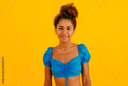 Smiling young woman against yellow background photo