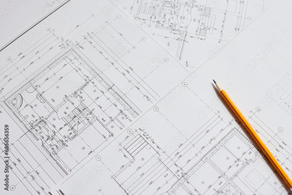 pencil and office tools for writing on the blueprint of construction industry. Place the rolls on a desk over blurred blueprint for construction industry background. - obrazy, fototapety, plakaty 
