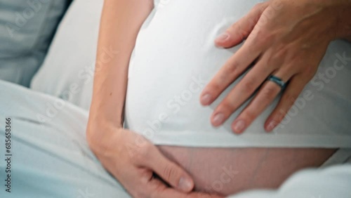 Wallpaper Mural A young pregnant girl with a large stomach, sits at home on the sofa and touches her stomach with her hands. Torontodigital.ca