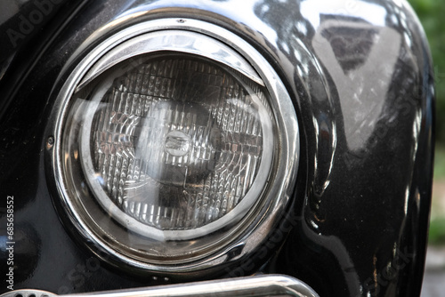 Classic round headlight of an old timer car, front view. Close up © evannovostro